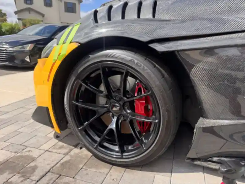Clean black wheel with a red brake caliper and dressed tire on the Toyota GR Supra